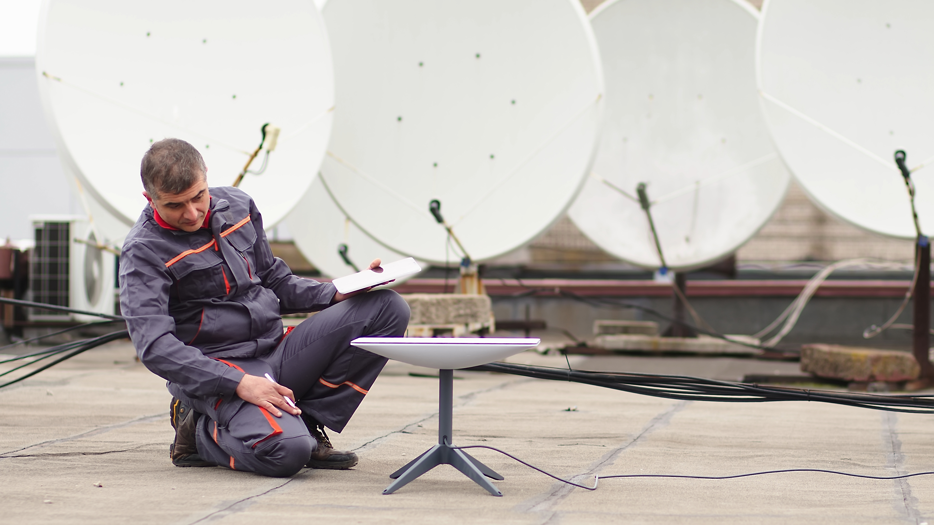 Deploying SatComms Person setting up satellite dish